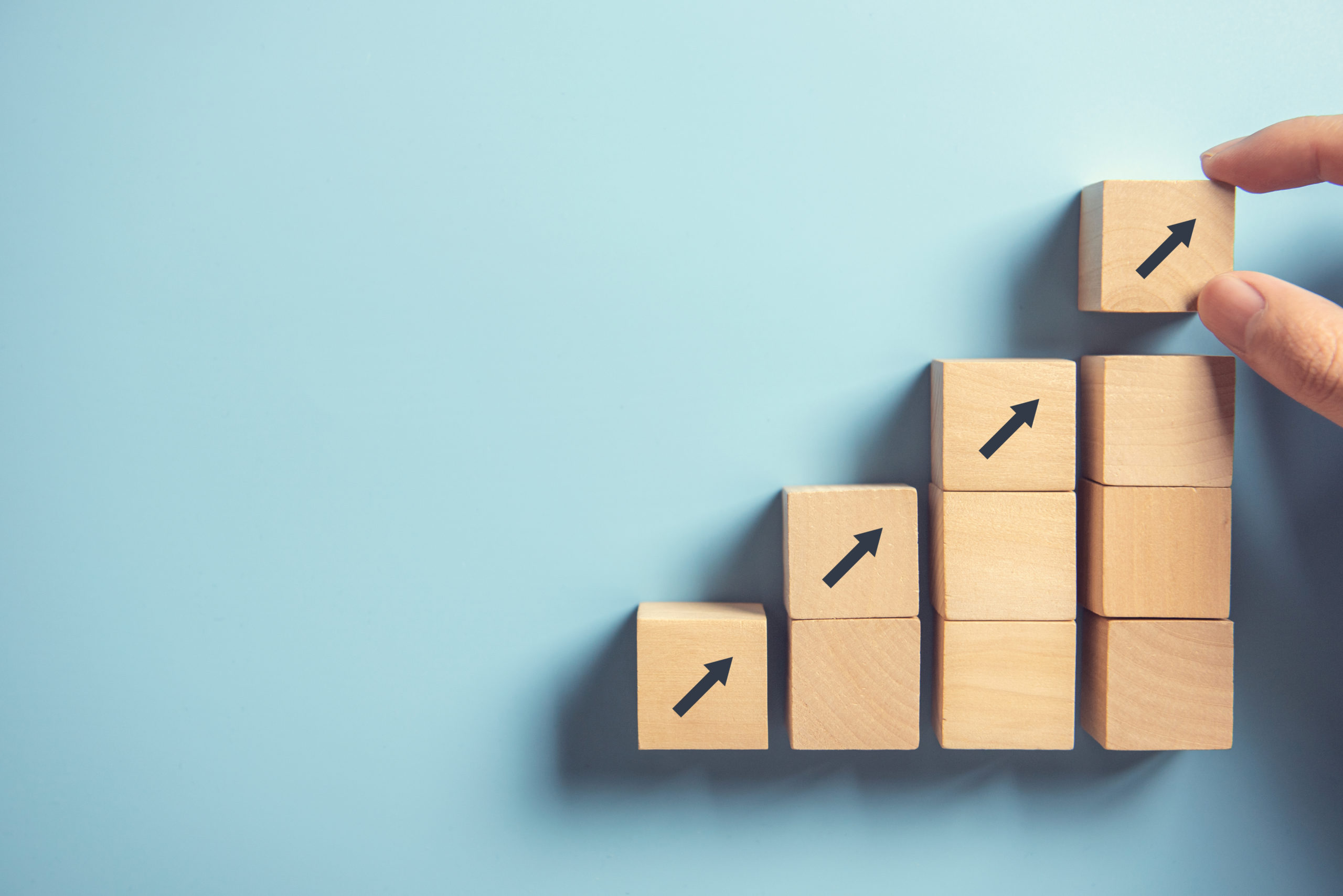 hand arranging wood block stacking as step stair on paper pink background. business concept growth success process, copy space.
