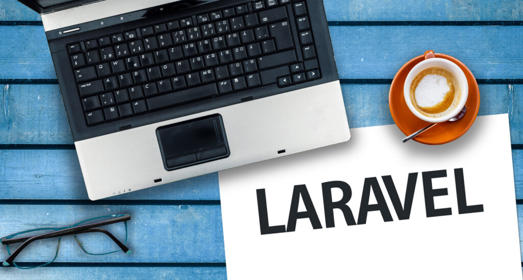 word laravel on paper and laptop