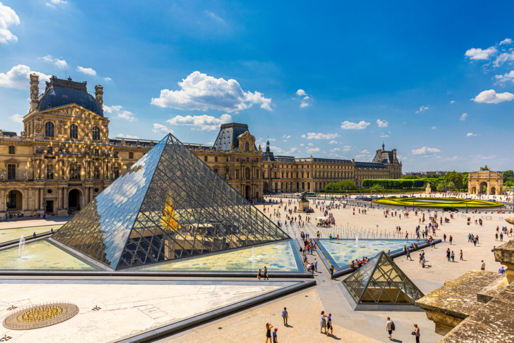 view of the louvre museum, the world's largest art museum and a historic monument in paris, france, on a sunny day. panoramic view of louvre museum and it's courtyard.