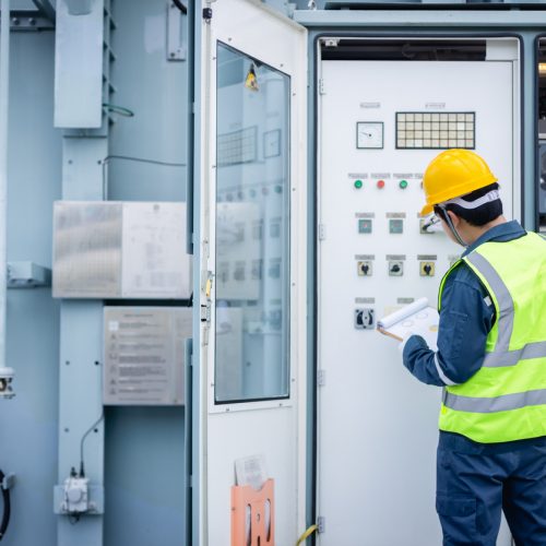 engineer is working on high voltage power substation performing inspection and check of electrical infrastructure to ensure safety and proper operation of system